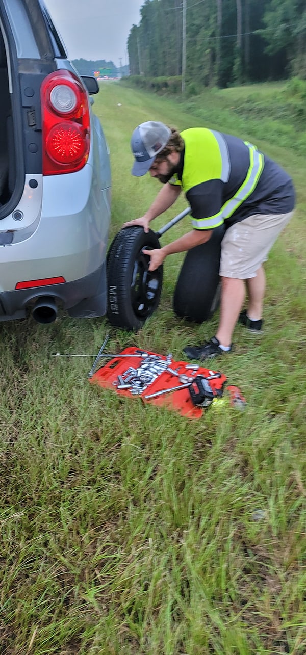 changing a tire in grass on side of 17 bypass