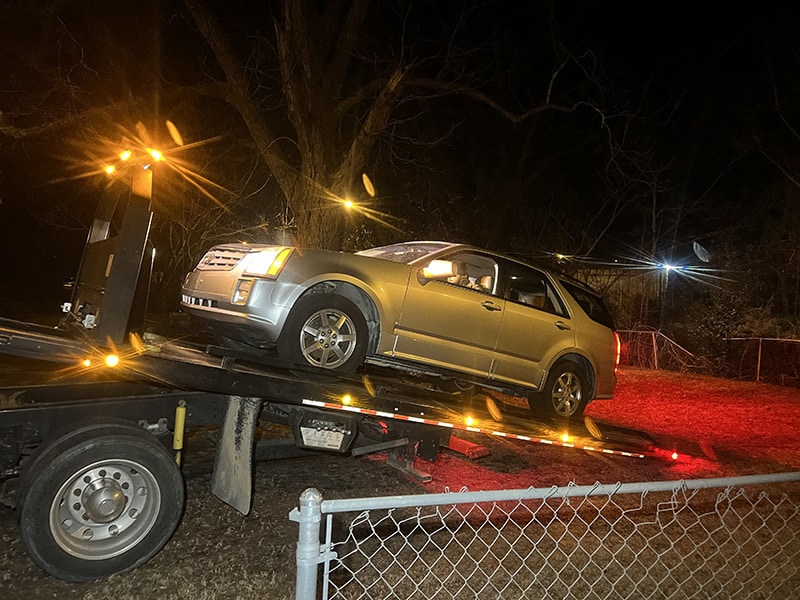 car loaded onto back of flat bed tow truck
