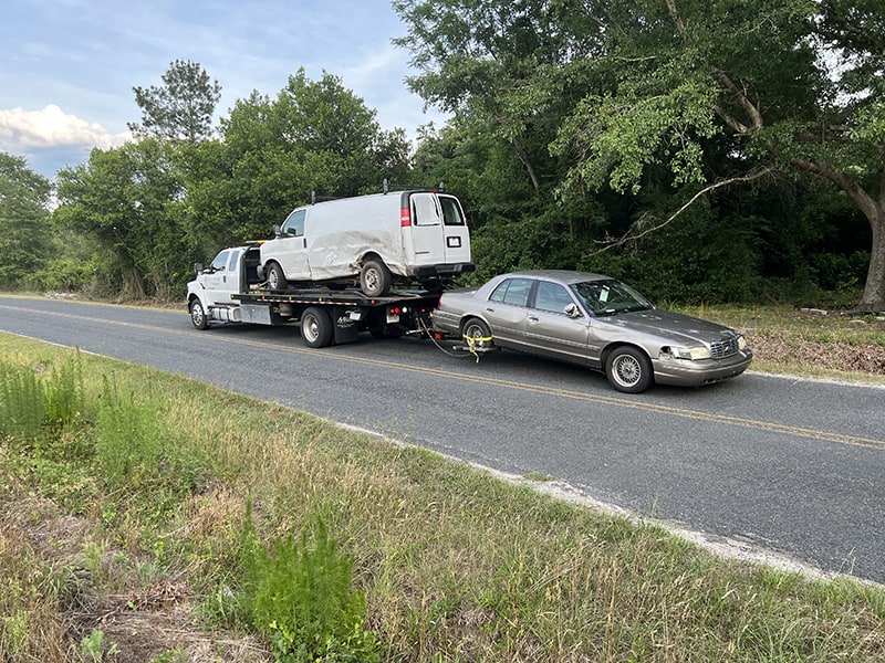 888 Tows truck with both a white van and grey car being towed