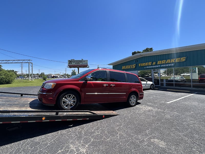 red minivan being put on flat bed tow truck in Murrells Inlet