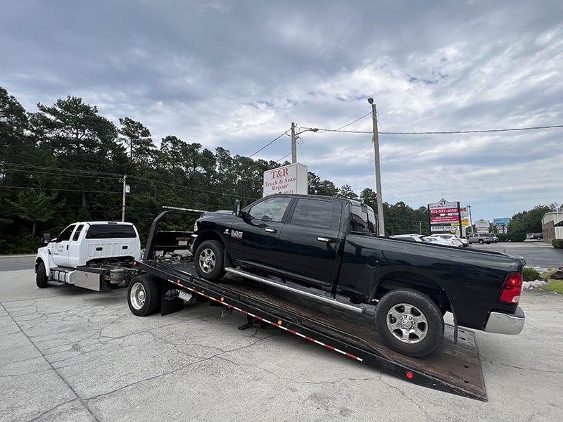 black truck on flat bed tow truck
