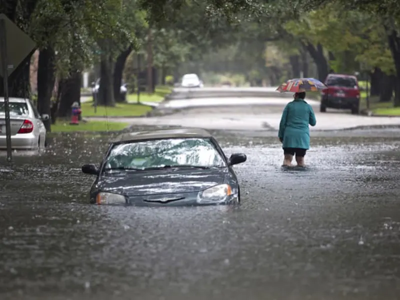 woman next to flooded car